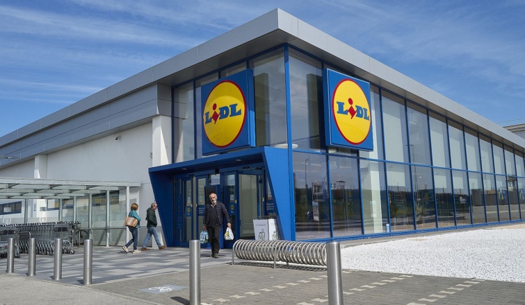 Egy Lidl bolt érkező és távozó vásárlókkal nappal.