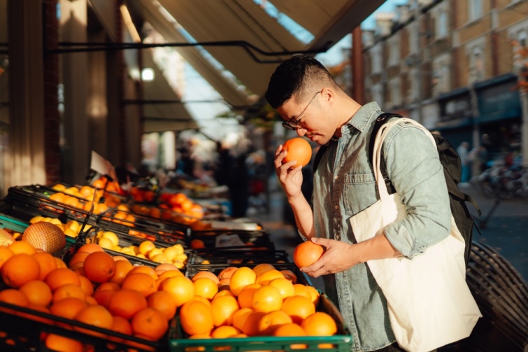 Fiatal ázsiai férfi gyümölcsöt vásárol