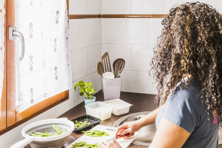 Műanyag vágódeszkán vágó nő