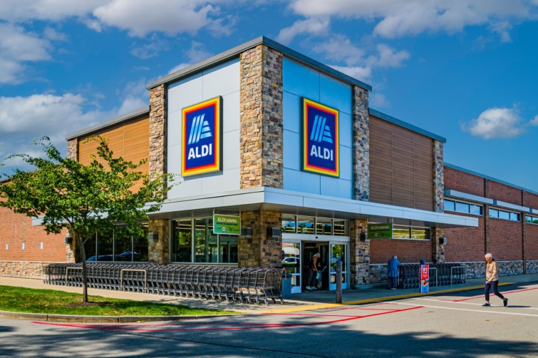 aldi Startlap Vásárlás Az Aldi egyik üzlete előtt bevásárlókocsik és érkező vásárlók