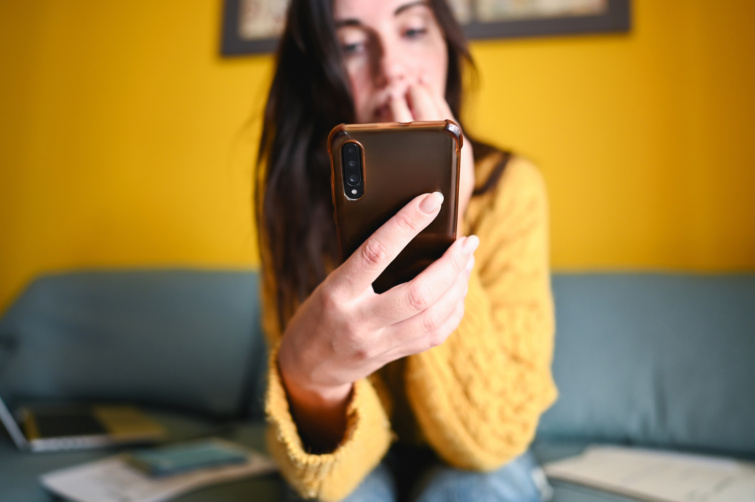 Aggódó lány nézi a telefonját
