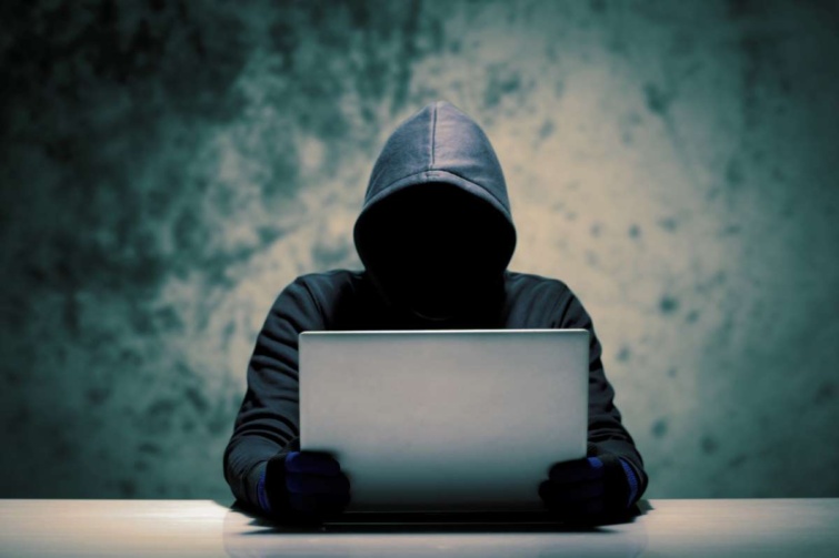 Hacker ül a számítógép előtt egy asztalnál