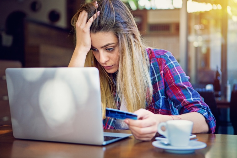 Egy fiatal nő a laptopja előtt mérgelődik