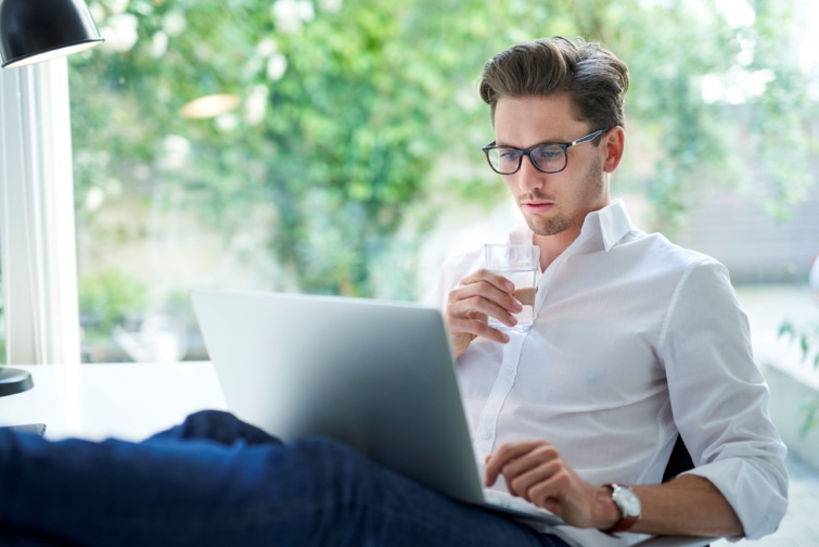 laptop Startlap Vásárlás Laptopját az ölében tartó, dolgozó férfi.