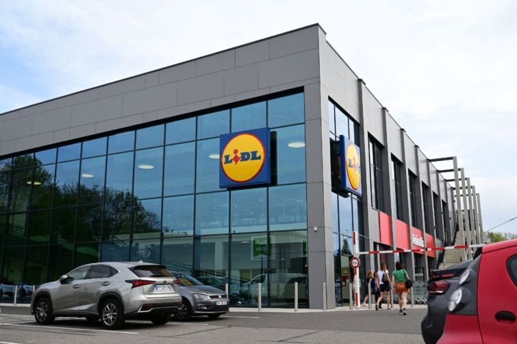 A Lidl egyik üzlete előtt parkoló autók és emberek
