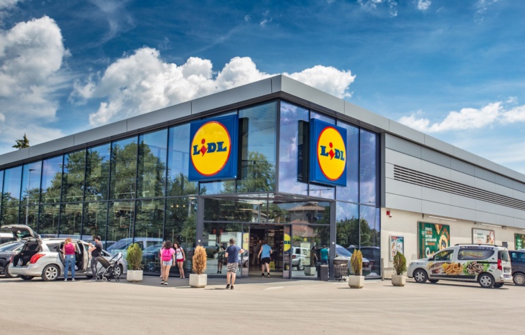 Vásárlók mennek a Lidl egyik üzletébe.