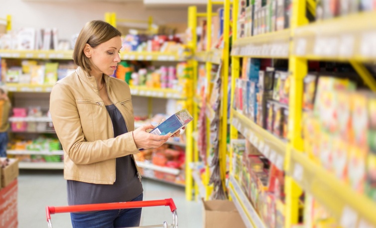 woman buys tea Startlap Vásárlás Egy nő a boltban egy doboz teát vizsgál.