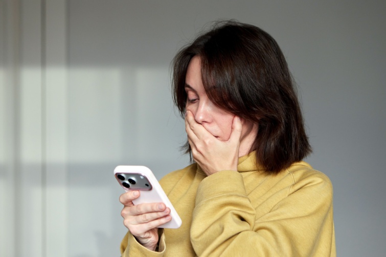 telefon Startlap Vásárlás Aggódó nő nézi a telefonját.