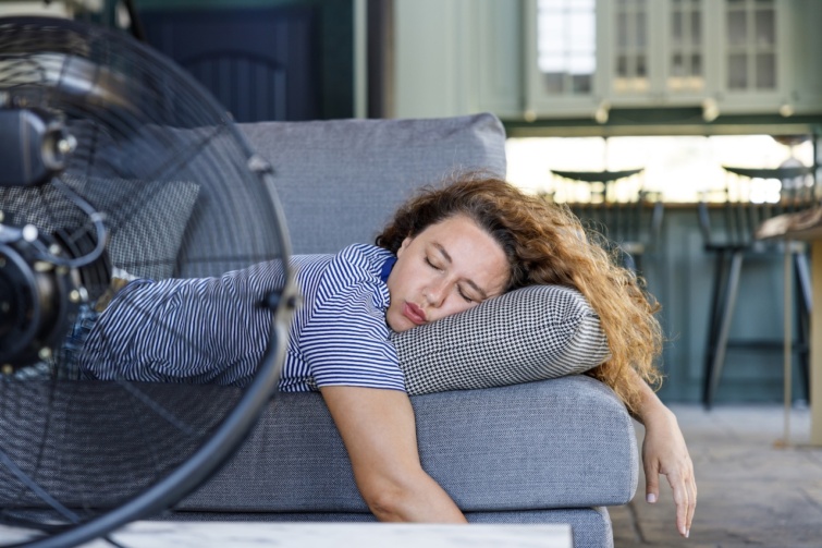 Fiatal nő ventilátor előtt alszik