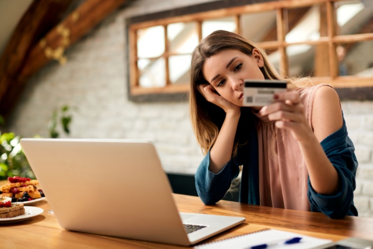onlinevasarlasno Startlap Vásárlás Fiatal szomorú nőnek problémái vannak, miközben otthon laptopon keresztül használja a hitelkártyáját és az e-bankoláskor.