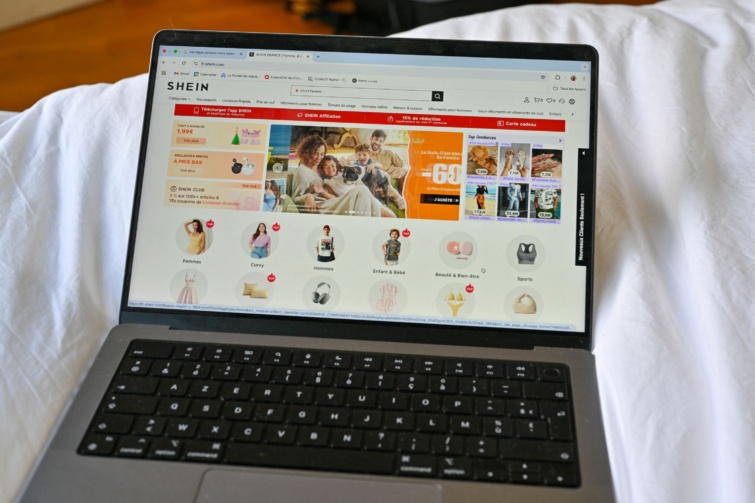 shein Startlap Vásárlás Fehér paplanon hever egy laptop, amin a Shein online vásárlói felülete látható