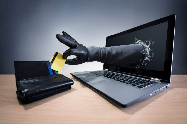 - Startlap Utazás Egy kéz nyúlik ki a laptop képernyőjén, és éppen elemel egy tárcából egy bankkártyát