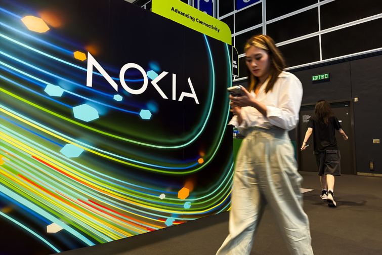 Nokia bejelentése Startlap Vásárlás Fiatal ázsiai nő a Nokia táblája előtt, kezében telefonnal