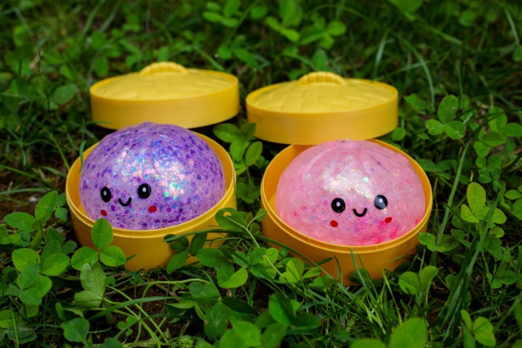 squishy dumpling Startlap Vásárlás Fotón a népszerű squishy dumpling figura. A műanyag dobozban a csillogó stresszoldó játék mosolygós figurája látható.
