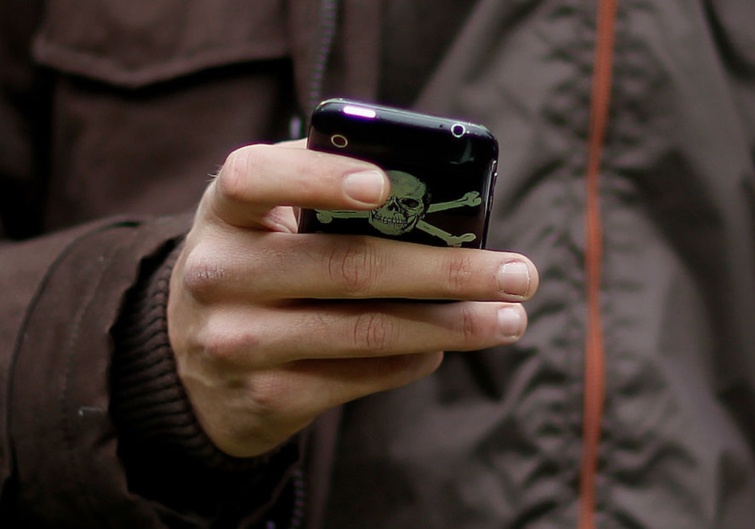 telefonkez Startlap Vásárlás Egy hacker kézben tart egy telefont.