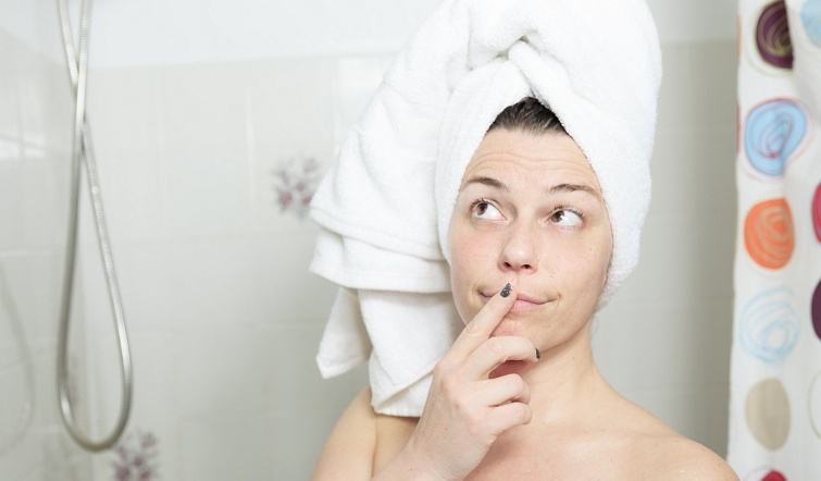 Shower Thinking Startlap Vásárlás Fiatal, törölközőbe csavart hajú nő gondolkodik a zuhanyzóban.