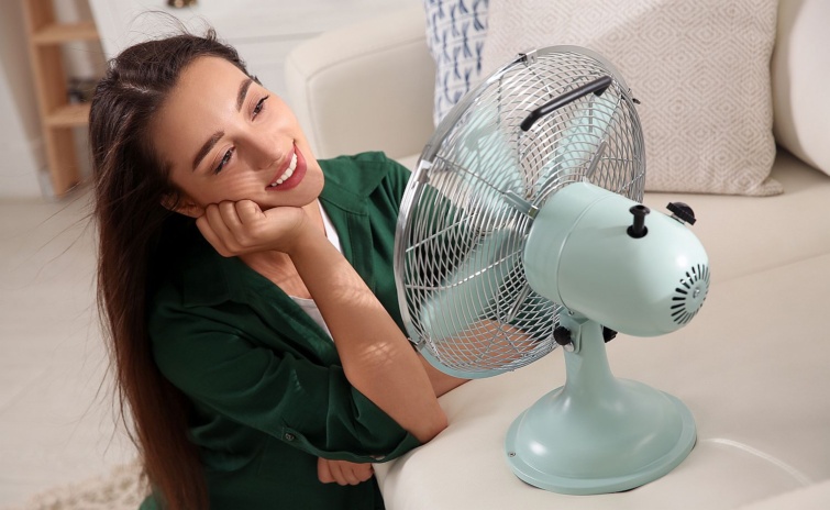 Woman enjoying air flow from fan at home Summer heat Startlap Vásárlás Fiatal, mosolygó nő a ventilátor előtt