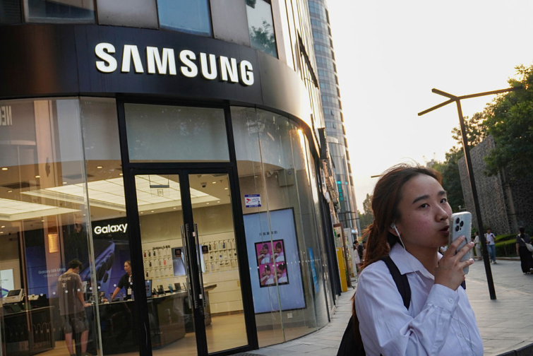 Ezeket a gyári Samsungbeállításokat módosítsd Startlap Vásárlás Fiatal nő kezében okostelefonnal egy Samsung-üzlet előtt