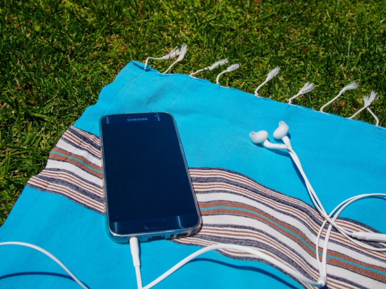 Samsung Galaxy forr Startlap Vásárlás Egy régebbi Samsung okostelefon készülék nyáron egy kék színű törülközőn a napon