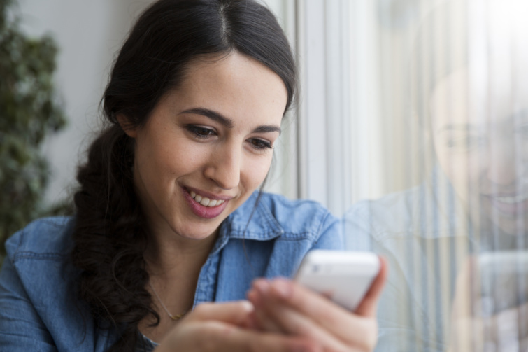 mobil Startlap Vásárlás mobilozó fiatal nő