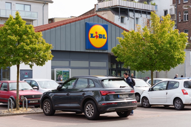 A Lidl új termékét a villanyszerelők szerint mindenkinek használnia kellene Startlap Vásárlás Egy Lidl áruház bejárata, előtte parkoló autókkal, az egyikből egy férfi szálll ki