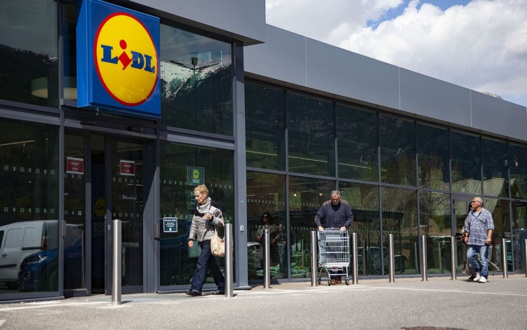 LIDLSUPERMARKETBRANDSTORE Startlap Vásárlás Vásárlók egy Lidl üzlet bejárata előtt.