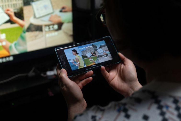 Hogyan nézheted a telefon képernyőjét a tévén WiFi nélkül Íme az egyszerű HDMImegoldás Startlap Vásárlás Egy Huawei-felhasználó a Huawei új termékbemutatójának élő közvetítését nézi mobiltelefonján és tévéjén Sanghajban, Kínában, 2023. május 18-án.