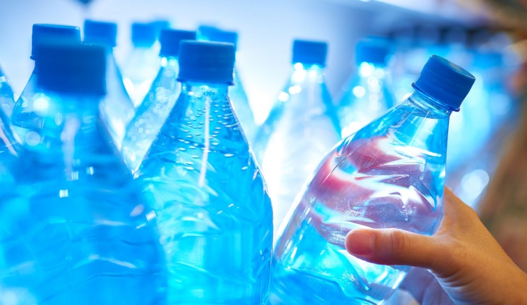 Clean bottled water Startlap Vásárlás Egy kéz leemel a polcról egy palack ásványvizet a boltban.