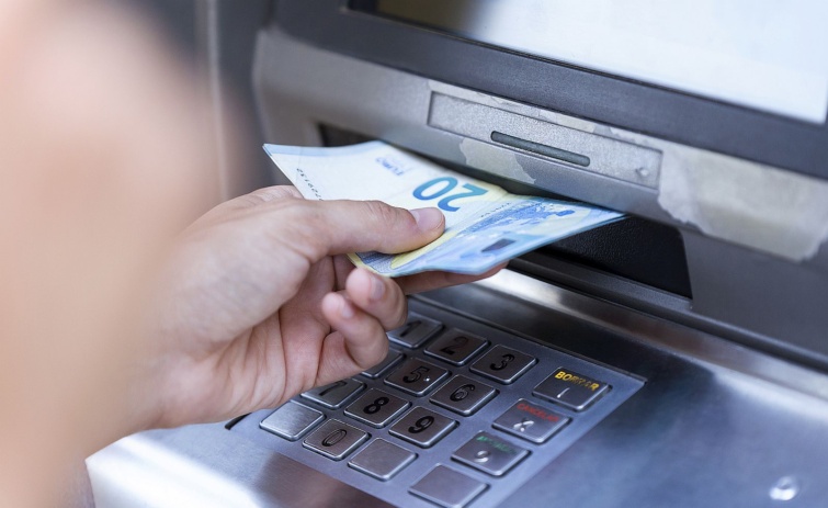 Bankjegyeket vesz fel egy kéz egy ATM-ből.