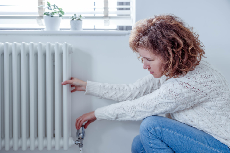 Októberben kezdődik ezt a hibát ne kövesd el a fűtés bekapcsolásakor Startlap Vásárlás Fiatal nő állítja a radiátoron a termosztátot