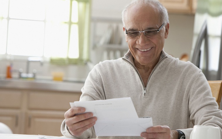 Hispanic man reading mail in kitchen Startlap Vásárlás Idős, szemüveges férfi levelet olvas.