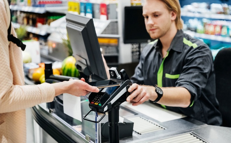Woman Paying For Groceries With Smartphone Startlap Vásárlás Egy nő mobillal fizet egy férfi kasszásnak