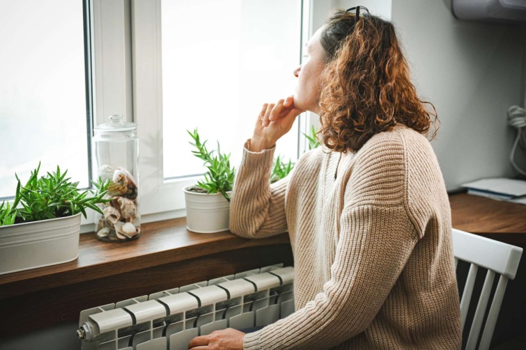 radiator Startlap Vásárlás radiátor előtt üldögélő nő