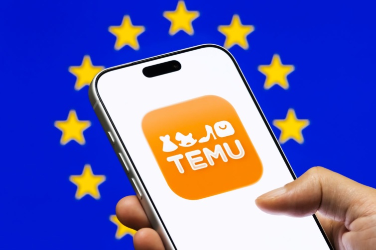 temu eu Startlap Vásárlás Európai Unió zászlaja mögött látható egy telefon, amin a Temu logója díszeleg.